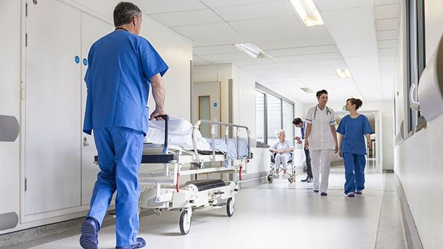 Doctors Hospital Corridor Nurse Pushing Gurney Stretcher Bed header image
