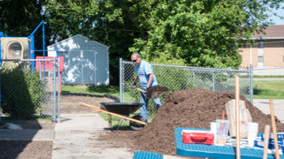 Convergint day male colleague picking up mulch