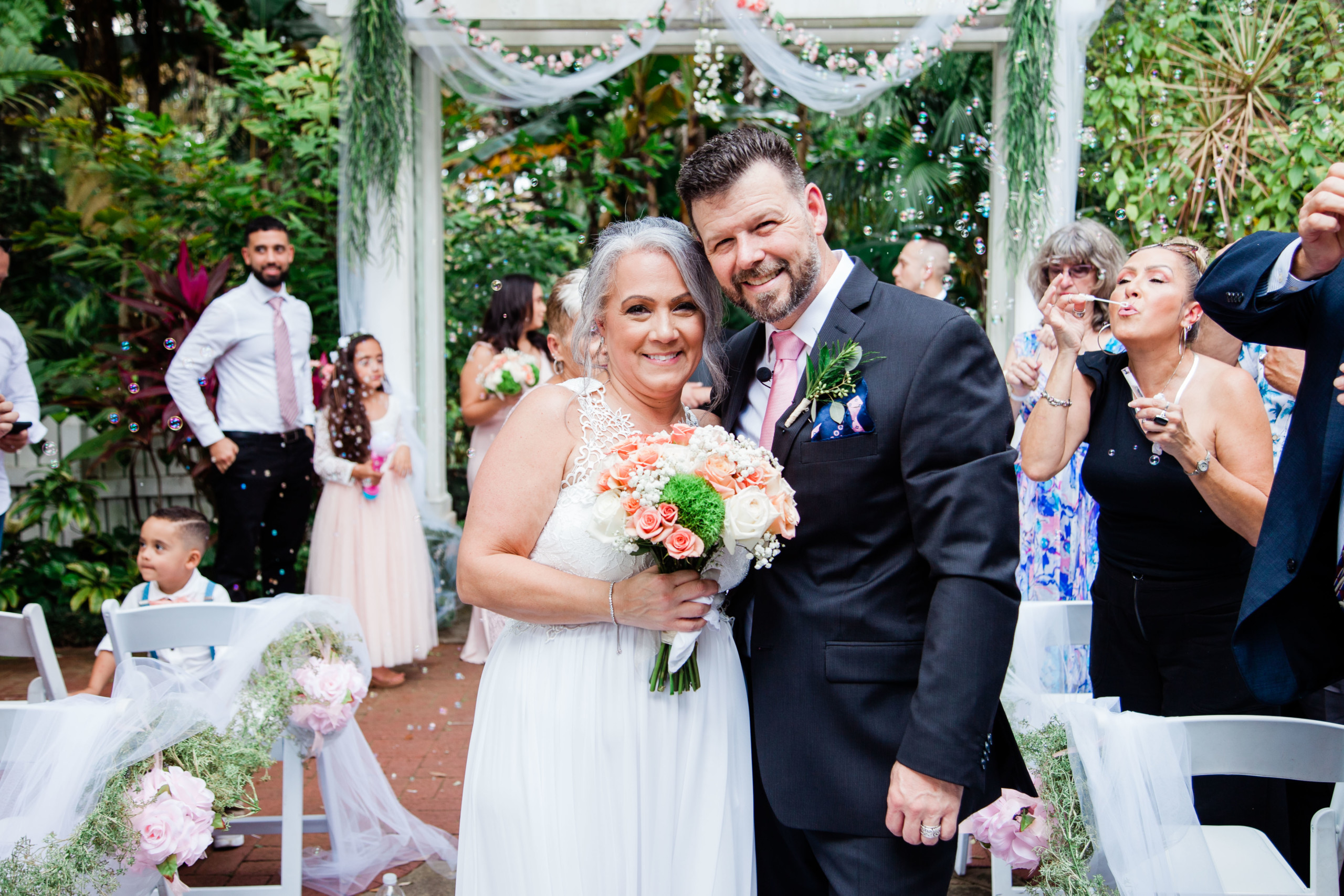 Bride and groom pose in the wedding aisle