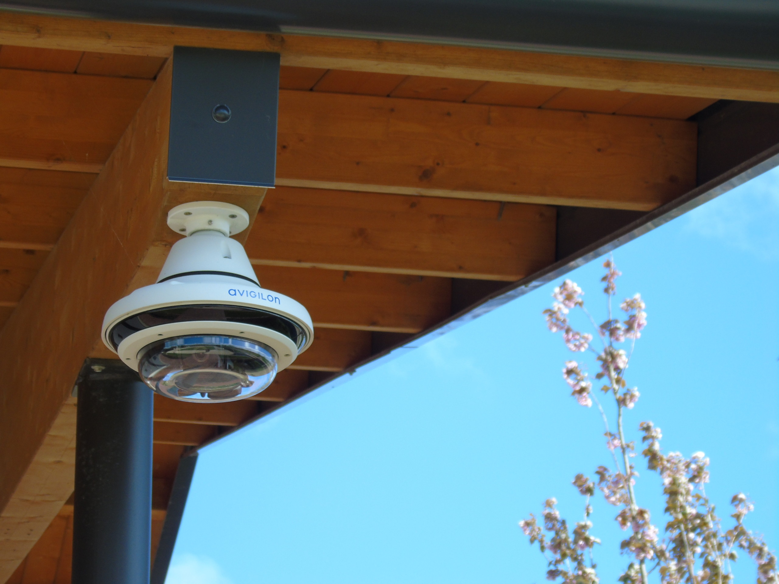 Camera on building roof with blues skies in background