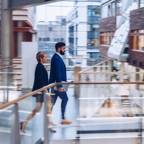 two people walking in an office