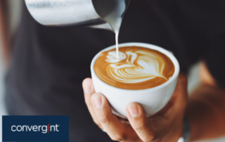 Man pouring milk into a coffee to create latte art