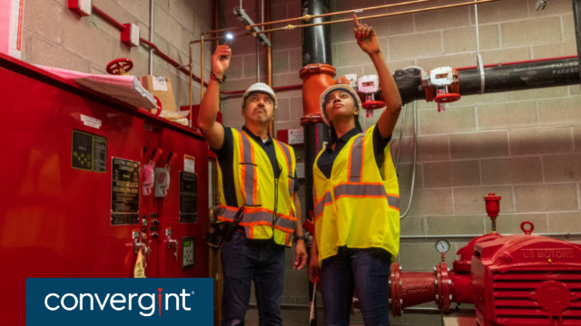 Male and female engineers servicing fire alarm system