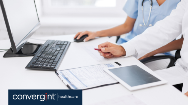 Female and Male doctor and nurse looking at reports and on computer