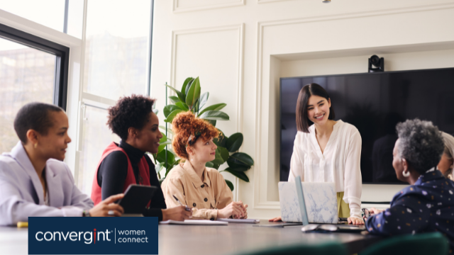 five women working around a conference table