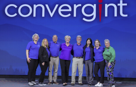 Eight people smiling on stage for a picture