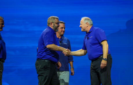 Two men shaking hands on stage