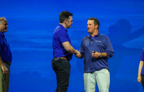 Two men shaking hands on stage