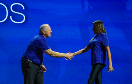 Men and woman shaking hands on stage