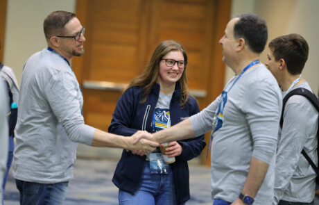 Two men shaking hands, two people talking