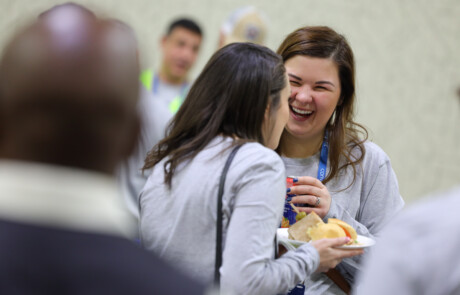 Two women laughing and eating