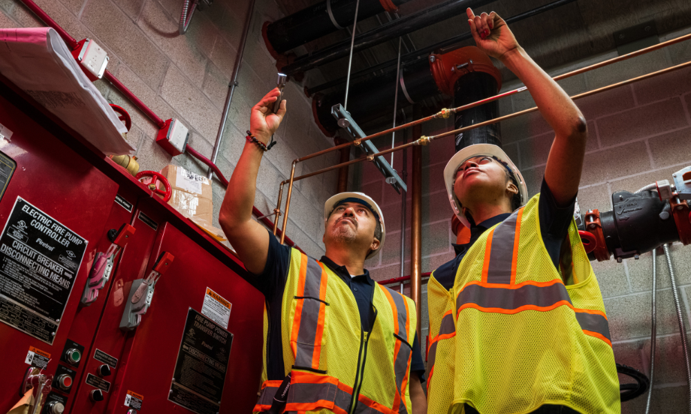 Two construction people pointing upward