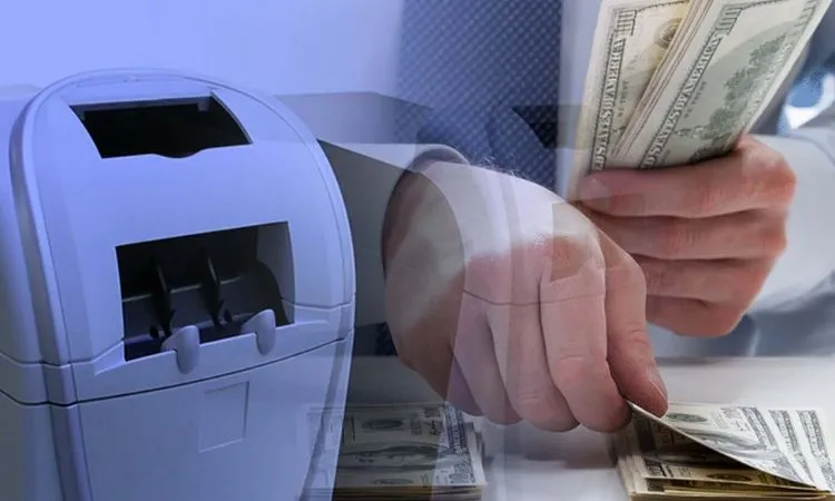 Person counting cash with a machine