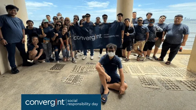 Un grupo de personas posa para una foto con una pancarta de Convergint