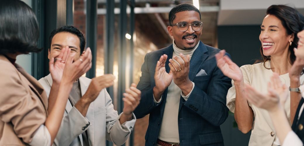 a group of people in a business clapping to celebrate
