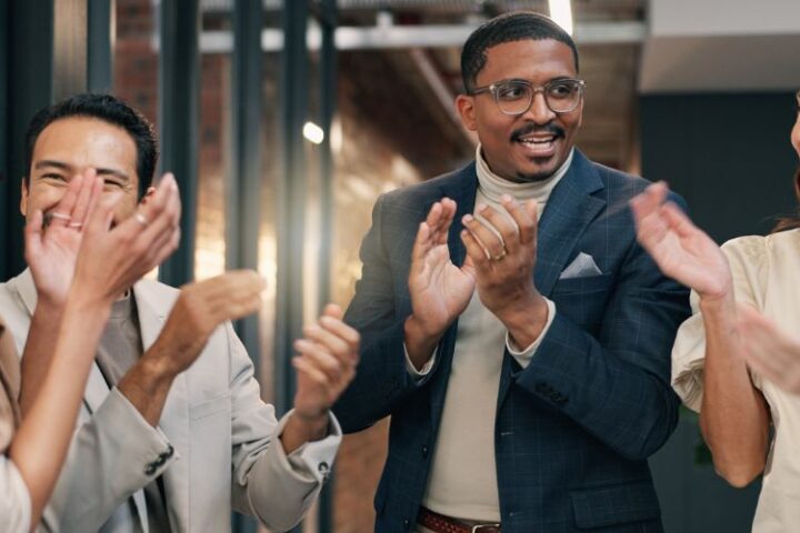 a group of people in a business clapping to celebrate