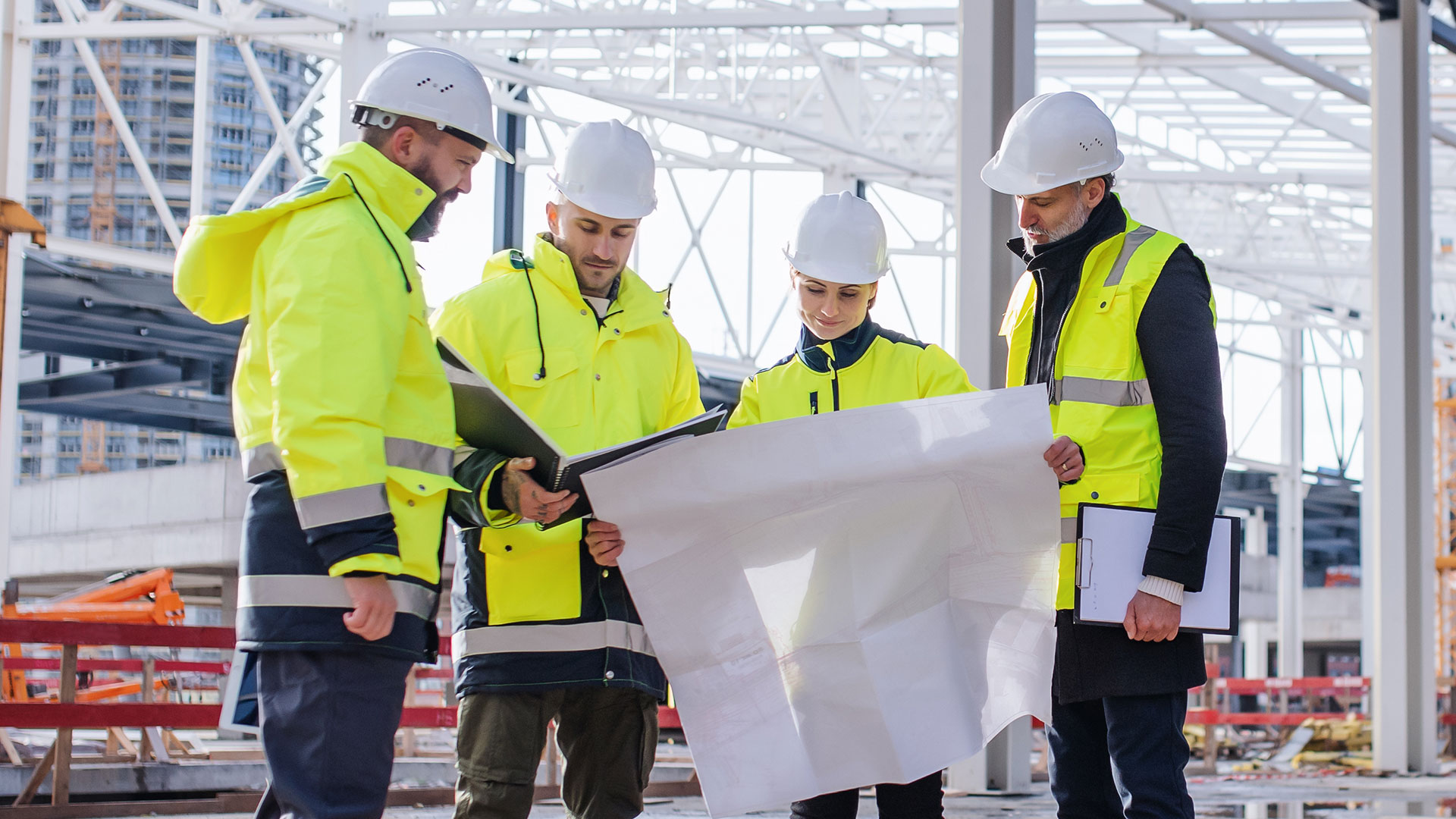 Four construction workers looking at design plans.