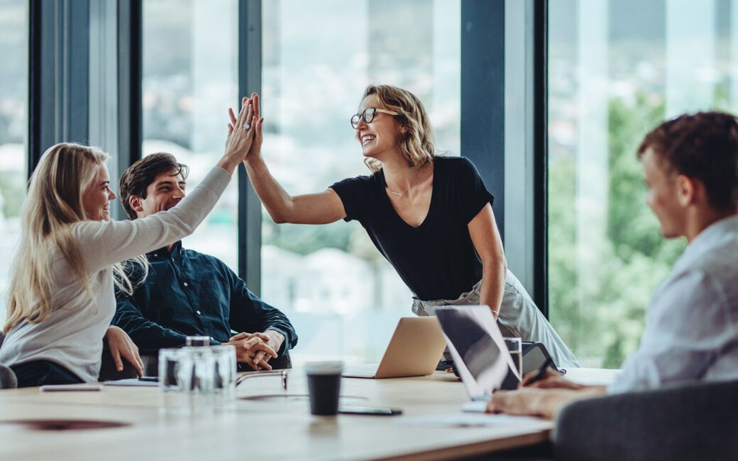 Two people high fiving across a table
