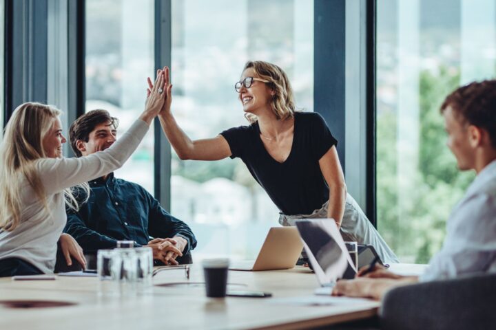 Two people high fiving across a table