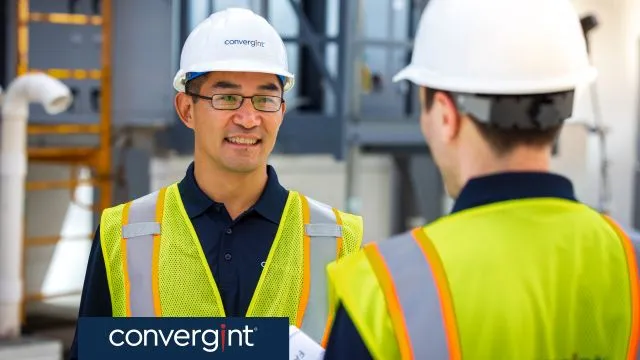 Dos trabajadores de Convergint con chalecos de seguridad y cascos