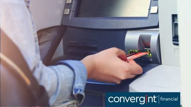 Una mujer introduciendo una tarjeta en un cajero automático