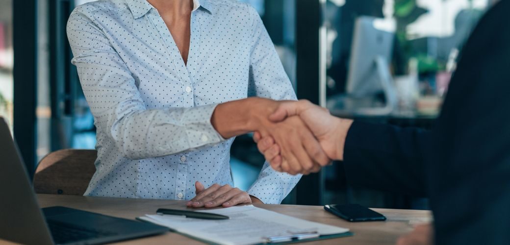 Man and woman shaking hands over a document
