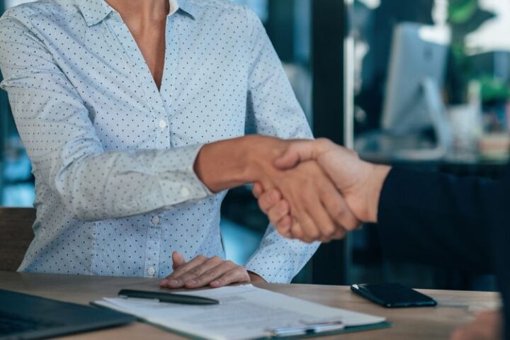 Man and woman shaking hands over a document