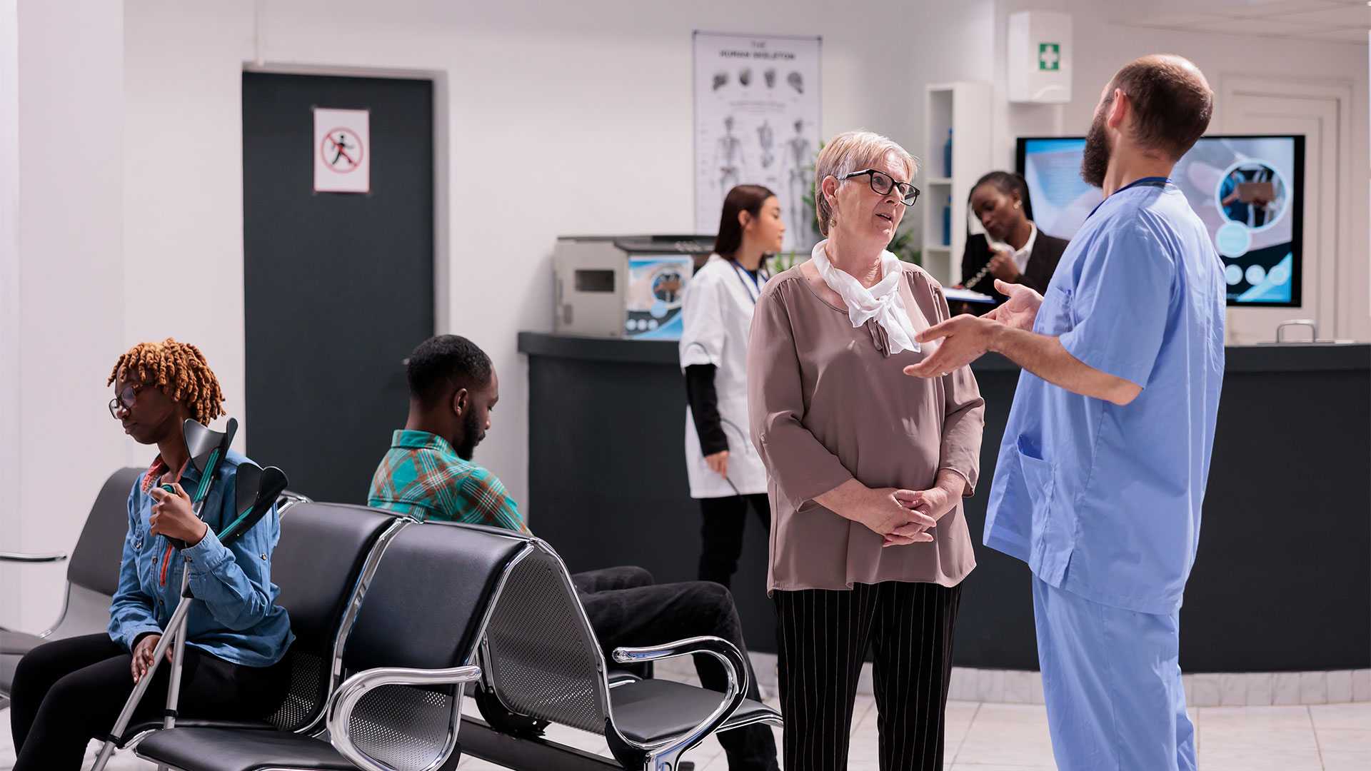 Clinic doctor speaking with a patient in a waiting room