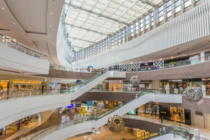 an interior view of a lavish, upscale mall with four floors of multiple stores and hanging decorations